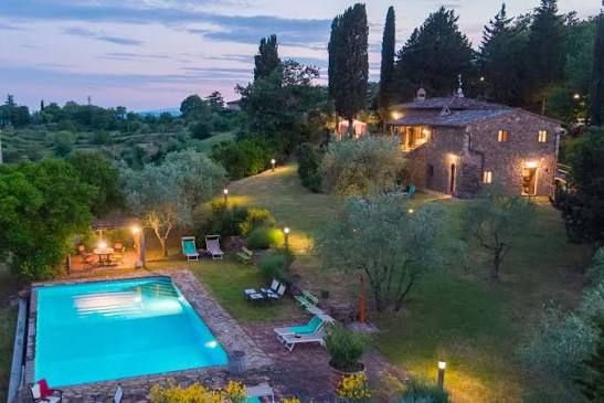 A Tuscan villa and swimming pool at dusk